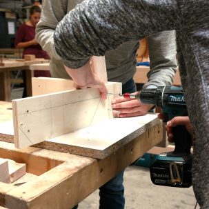 Construction de la structure en bois du tabouret lors de l'atelier d'initiation